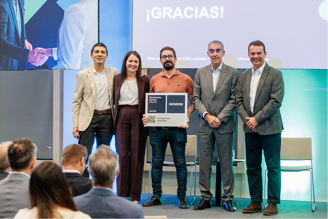 Carlos Fernández con el cartel de partner durante el encuentro de partners Siemens